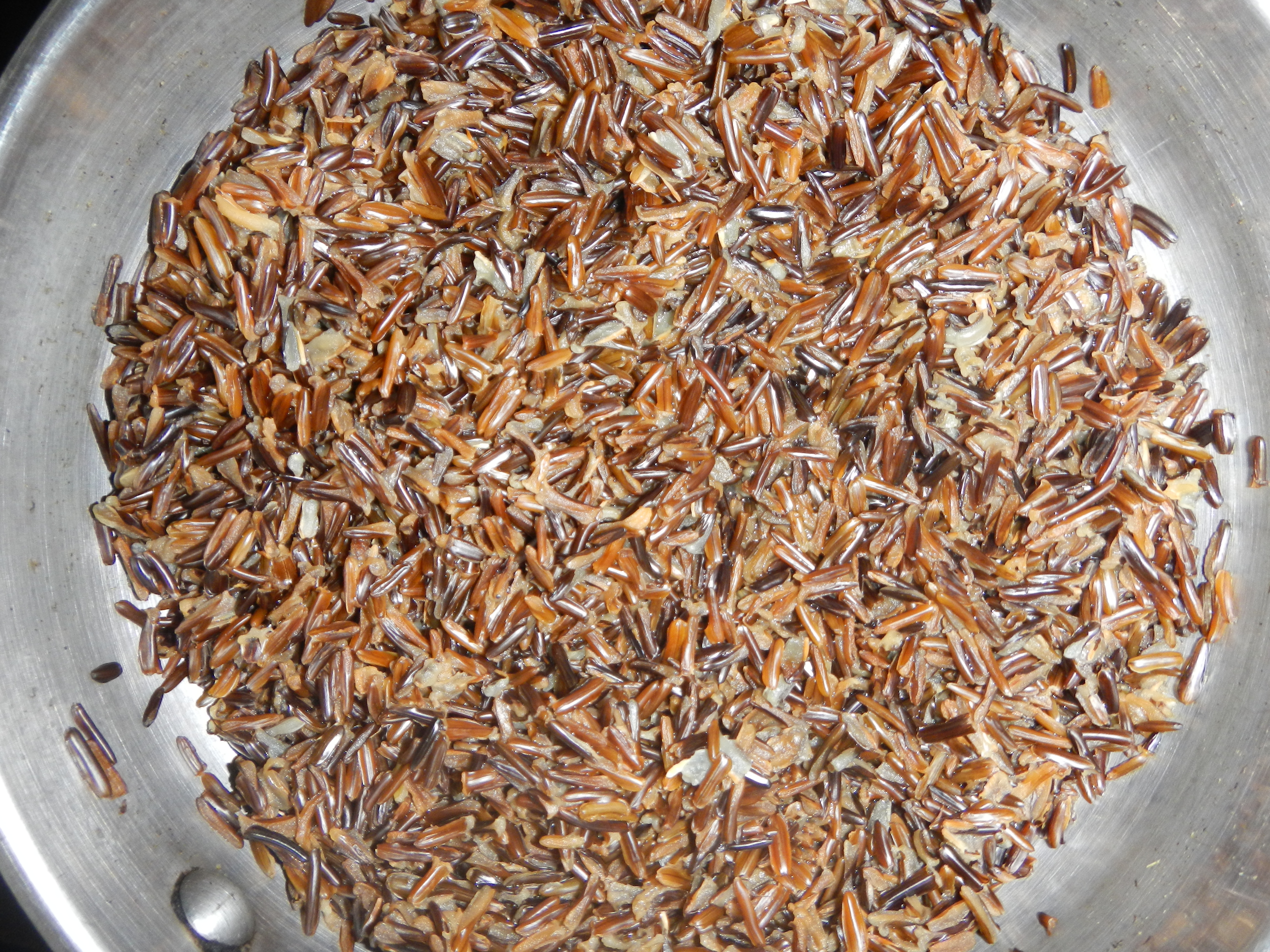 Image shows cooked wild rice in a pan